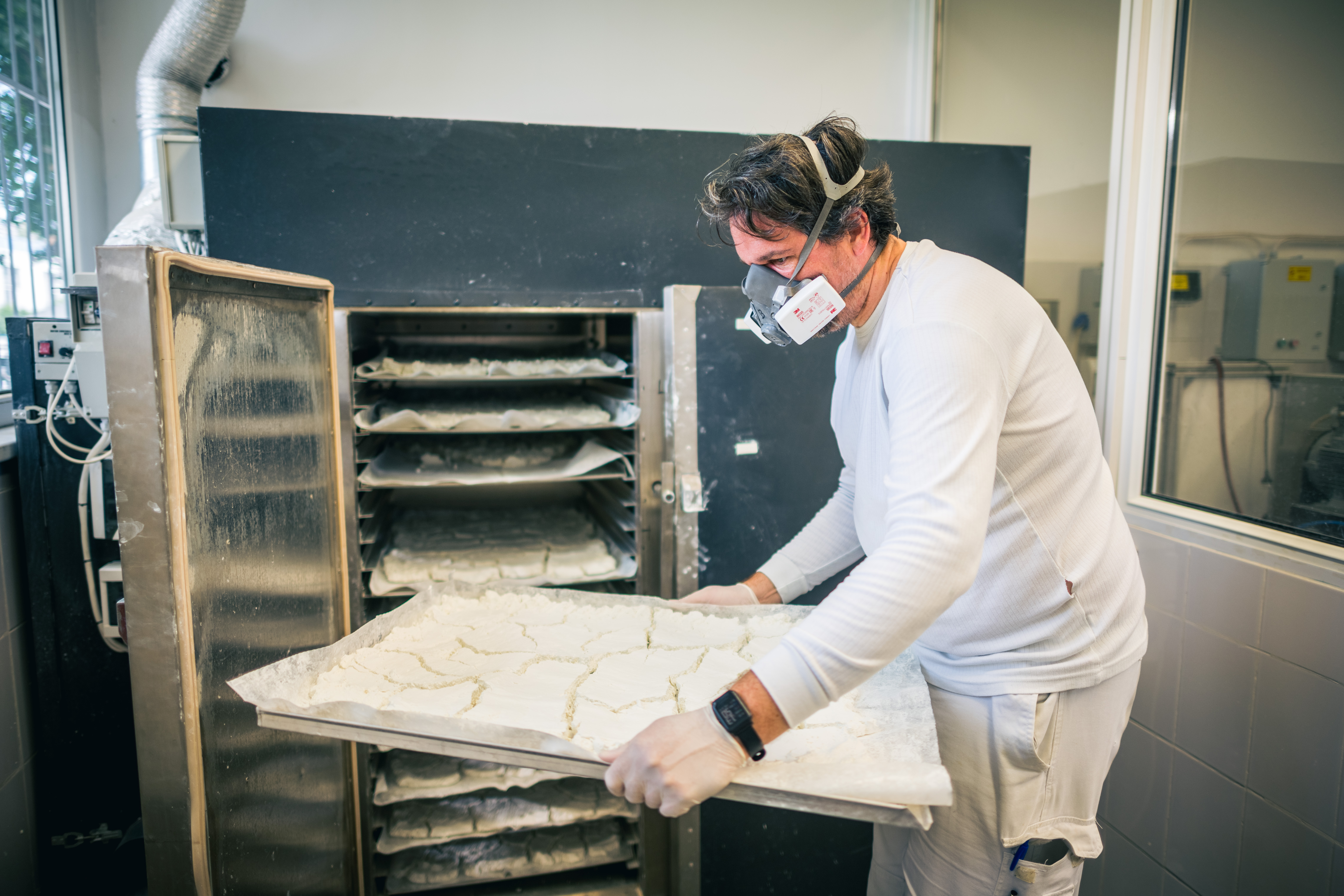Technician handling drying trays of pigment material